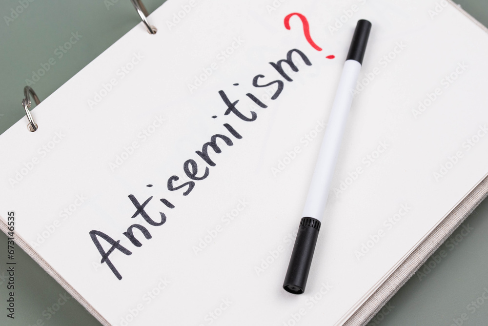 Antisemitism minimalistic concept. Word Antisemitism written on white paper with question mark. 
