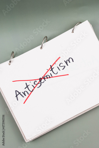 Antisemitism minimalistic concept. Crossed out with red lines Word Antisemitism written on white paper. photo