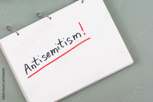 Antisemitism minimalistic concept. Word Antisemitism written on white paper with Exclamation point.  photo