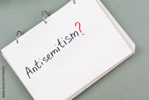 Antisemitism minimalistic concept. Word Antisemitism written on white paper with question mark.  photo