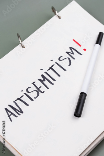 Antisemitism minimalistic concept. Word Antisemitism written on white paper with Exclamation point.  photo