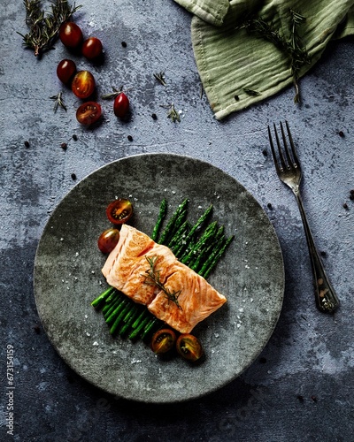 cenital view of a salmon with asparagus and cherry tomatoes  photo