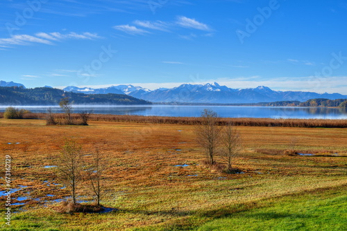 Der erste Schnee im Herbst vor dem Panorama der Alpen am Simssee in Bayern photo