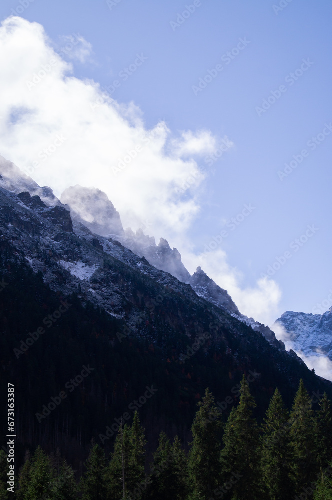 Obraz premium Cloud-Kissed Peaks: Autumn Majesty in the High Tatras of Poland