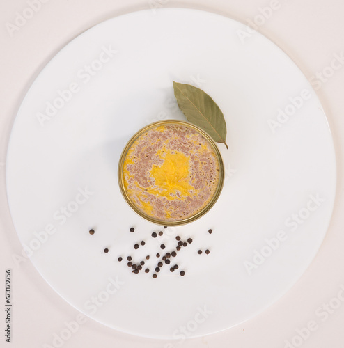 beef pork  liver pate in the tin can on the white plate with peppers 