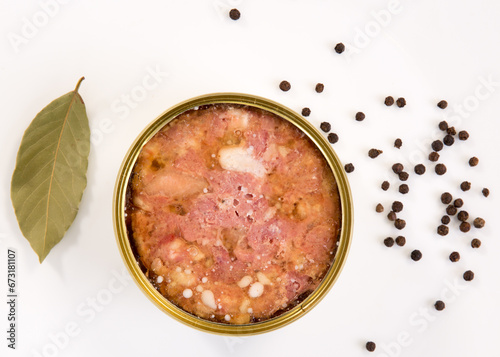 canned beef or pork meat on the white background plate with black peppers close view .