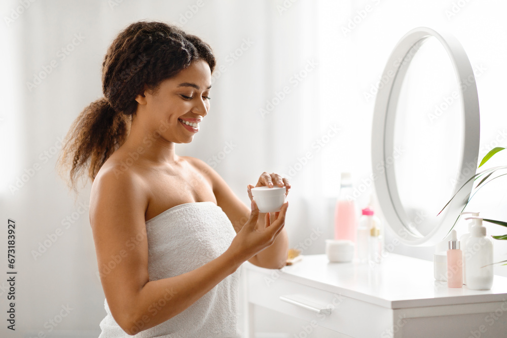 Cosmetics Concept. Beautiful African American Female Using Moisturising Cream At Home Cosmetics Concept. Beautiful African American Female Using Moisturising Cream At Home