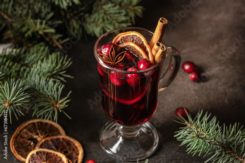 Christmas mulled red wine with spices and fruits on brown textured background. Traditional festive hot drink at Christmas time