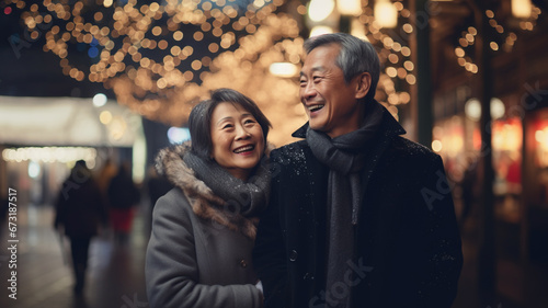 asian mature couple in love walks in the street with christmas lights