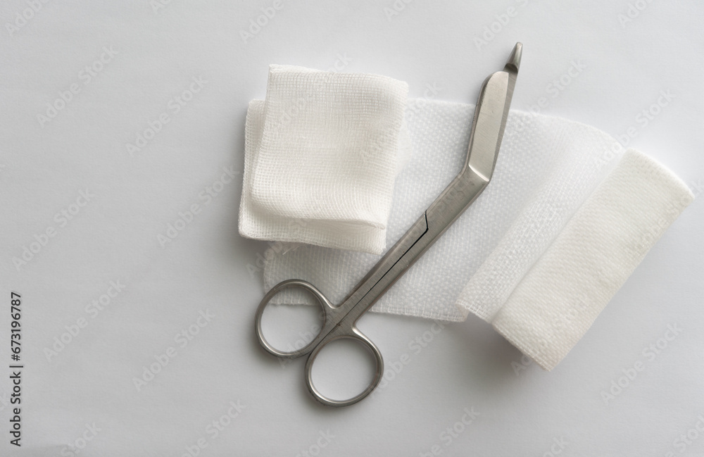 Fototapeta premium Dressing or clean wound tools includes Roll gauze,pile of gauzes and gauze roll cutter or scissors