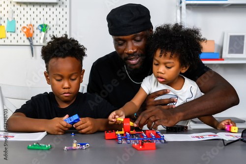 Loving Father Teaches and Plays with Son at Home for Learning and Education on Electric Circuit and Skill Development. Father Nurtures Child's Skills Through Play and Education Concept.