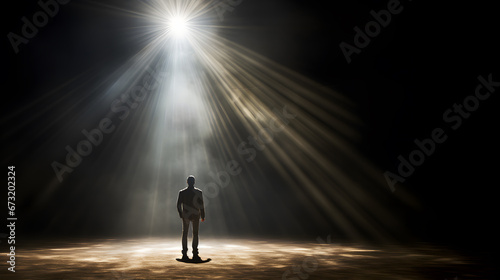 silhouette of a man standing in the spotlight