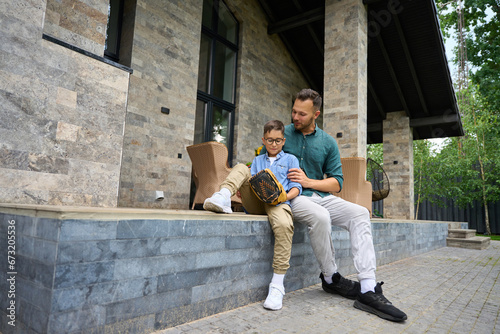 Young father communicates with his son on terrace of country house