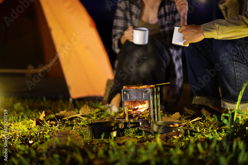 Fototapeta Naklejka Na Ścianę i Meble -  Close-up of barbecue meal grill in the wilderness of backpacker group. Grilled meals ready to eat for hiking groups, Camping in nature, Cooking at night with an atmosphere that is warm and inviting.