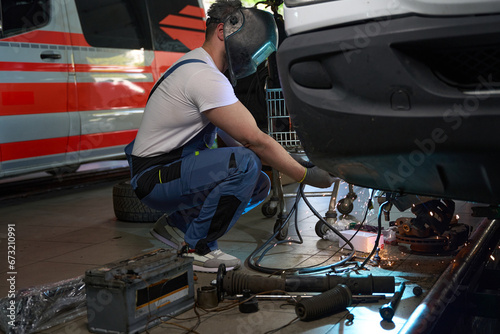 Skilled mechanic performing client automobile repair in workshop