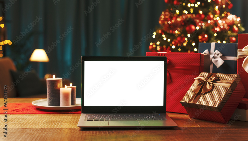 Fototapeta premium Laptop with blank screen, gifts and Christmas tree