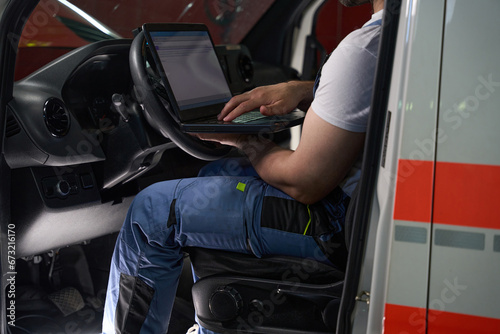 Obraz na płótnie Experienced auto mechanic performing computer diagnostic test on client car w salonie
