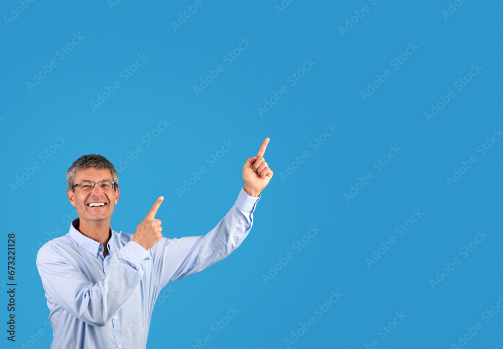 Excited businessman in shirt pointing to blank space aside, studio Excited businessman in shirt pointing to blank space aside, studio