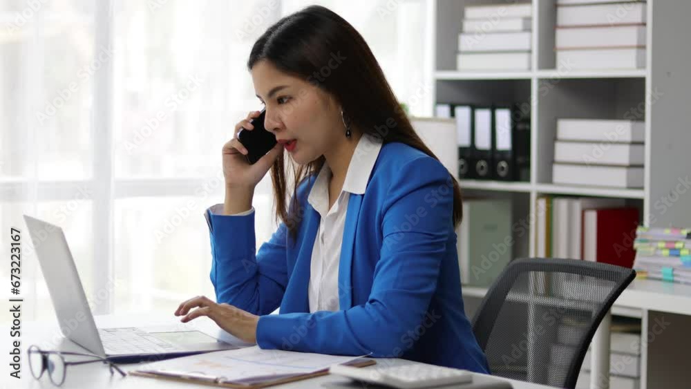 Asian businesswoman secretary in office talking on phone with boss. Asian businesswoman secretary in office talking on phone with boss.