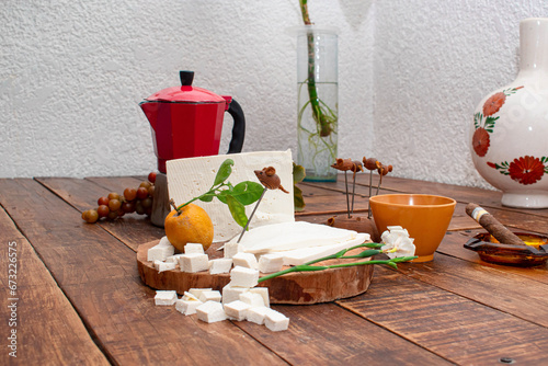 Mesa de una cocina con una tabla de madera con queso canasto en cubitos y acompañado de café  photo