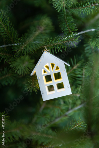 New Year's house garland on the background of a green Christmas tree, housewarming concept and comfort in your home for a holiday © Mari