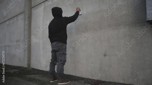 xenophobia antisemitism person drawing painting jewish david star symbol on the building wall with a spray can photo