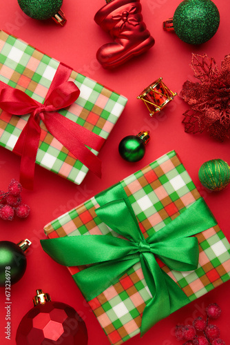Christmas composition. Green gifts, red and green decorations on red background. New year concept.