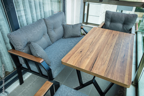 Modern chairs and wooden table in the apartment balcony. Winter garden concept.