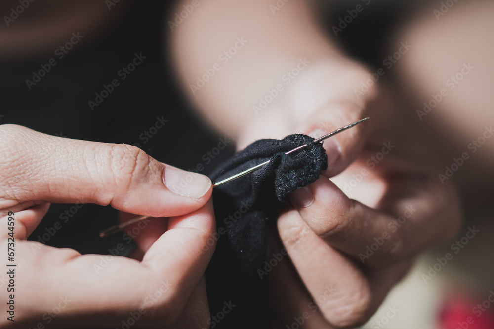 Woman fingers threading a needle