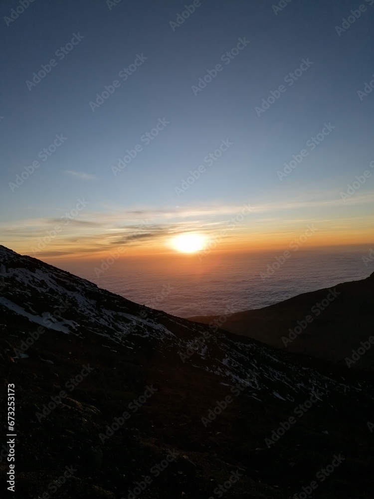 Orange sky at a stunning sunset above the clouds on Mount Kilimanjaro in Tanzania, Africa