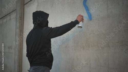 antisemitism xenophobia person drawing painting jewish david star symbol on the building wall with a spray can photo