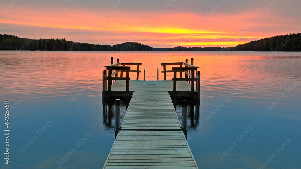 Wooden pier with a vibrant sunset sky in the background