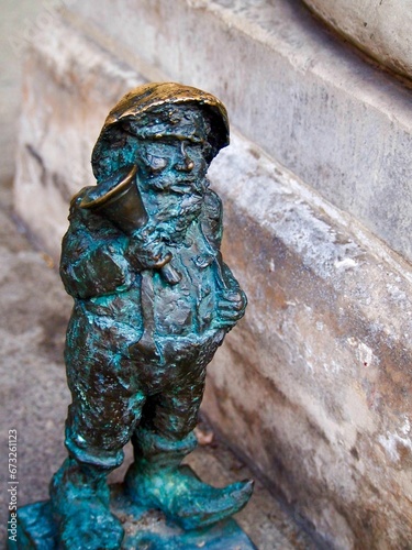 Closeup of a dwarf statue on a cobblestone street in Wroclaw, Poland