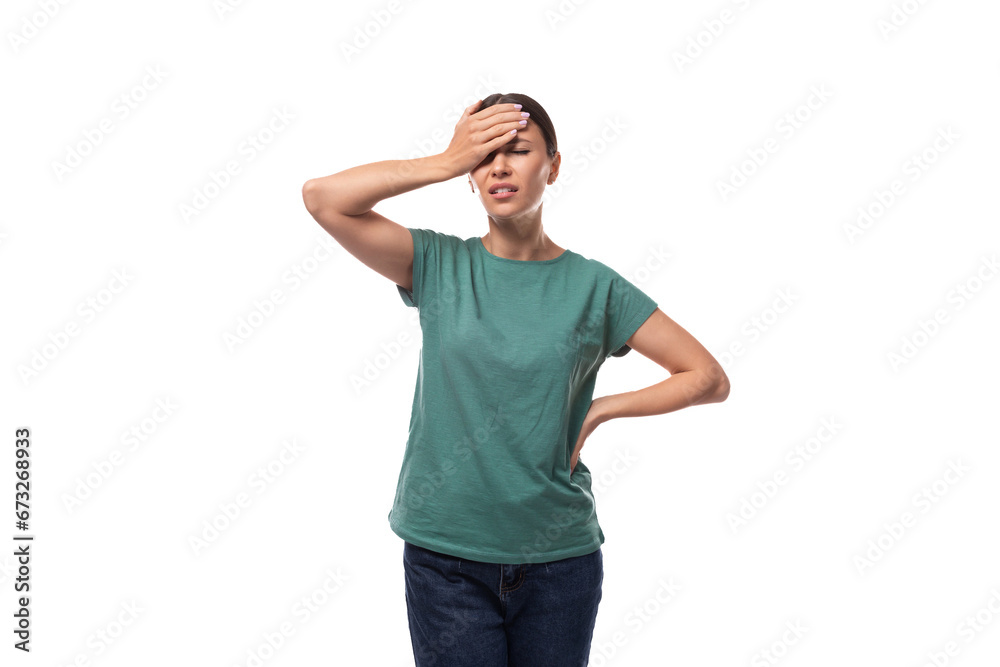 Fototapeta premium young beautiful brunette lady dressed in a green t-shirt and jeans thinking on a white background