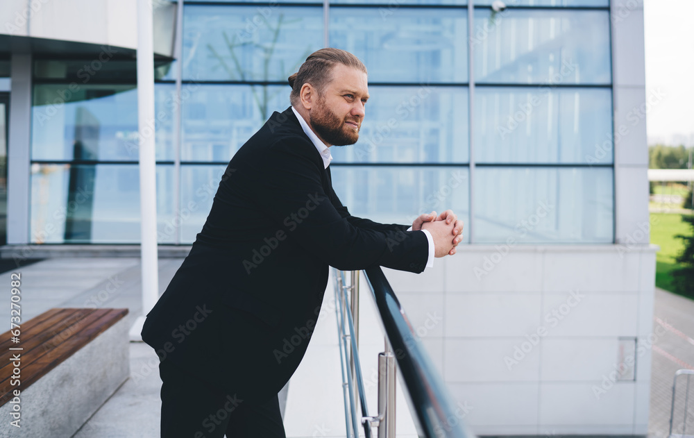 Thoughtful businessman standing on terrace at railing Thoughtful businessman standing on terrace at railing