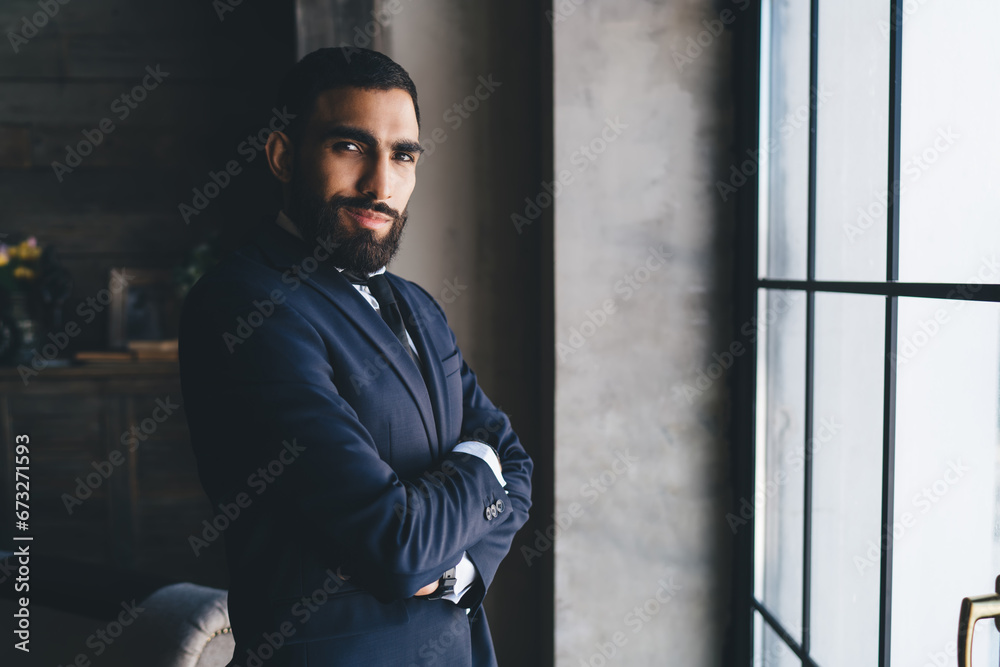 Smiling man standing with arms folded Smiling man standing with arms folded