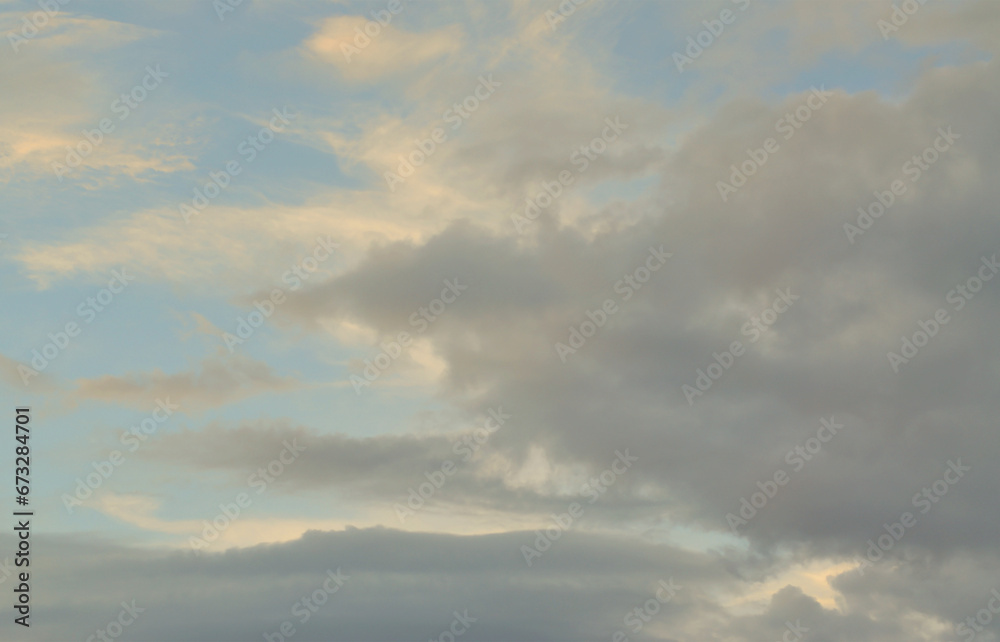 A blue cloudy sky with many small clouds blocking the sun A blue cloudy sky with many small clouds blocking the sun
