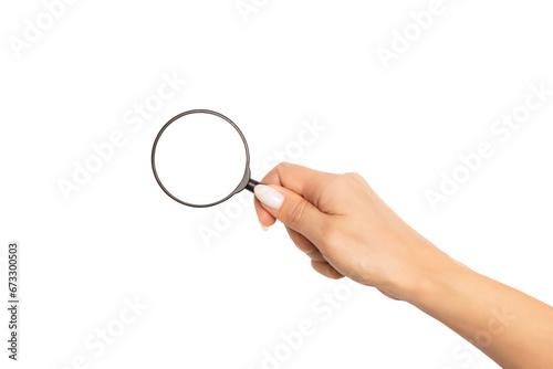An elegant female hand with a beautiful manicure holds a magnifying glass. Mockup or template with round empty space for text and design, isolated on white background.