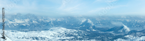 Winter hazy view from Dachstein mountain massif top and house on rocky slope  Austria .