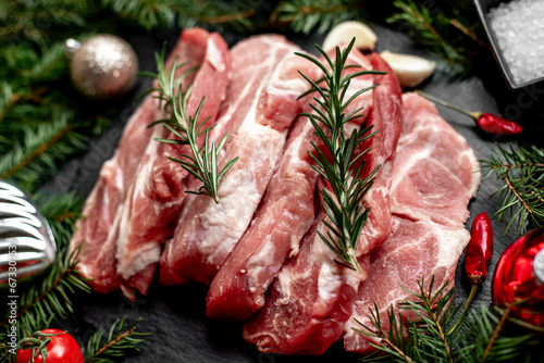 Christmas raw pork steaks on a background of a Christmas tree and Christmas toys