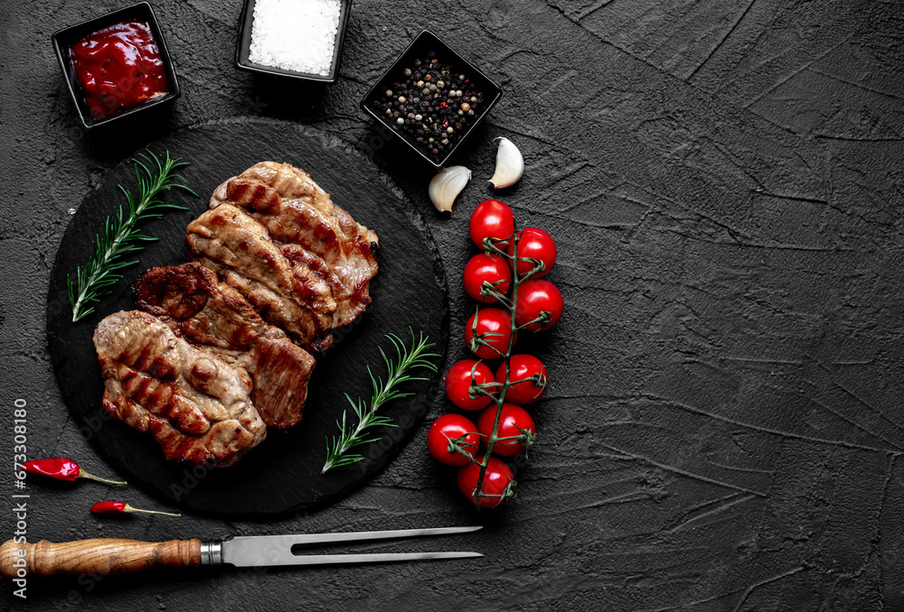 grilled pork steaks on stone background with copy space for your text	