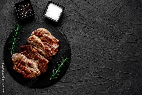 grilled pork steaks on stone background with copy space for your text	
