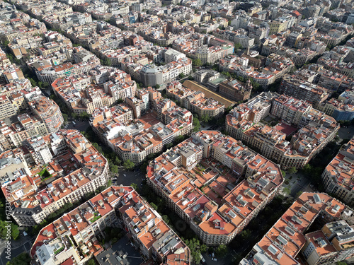 Aerial view of Barcelona Eixample residential district and Sagrada Familia Basilica at sunrise. Catalonia, Spain. Cityscape with typical urban octagon blocks