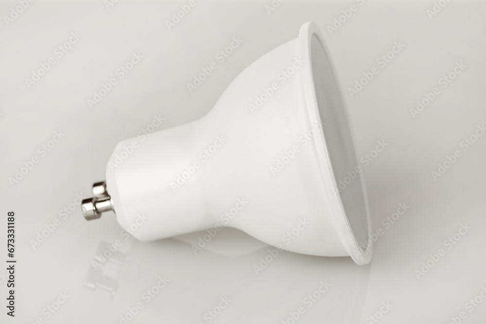 LED light bulb GU10 base, energy-saving energy conservation, isolated on light background LED light bulb GU10 base, energy-saving energy conservation, isolated on light background