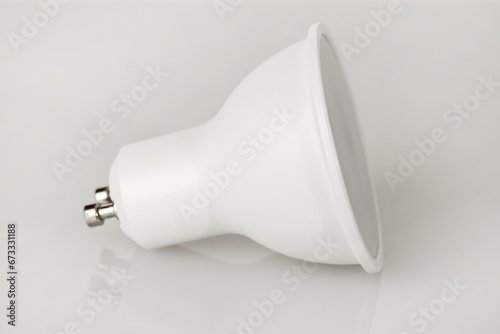 LED light bulb GU10 base, energy-saving energy conservation, isolated on light background photo