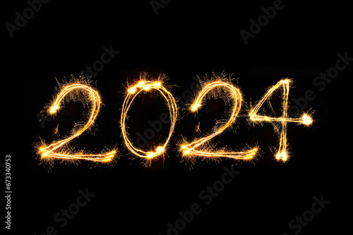 Happy new year 2024 text written with hand drawn golden Sparkle fireworks isolated on black background
