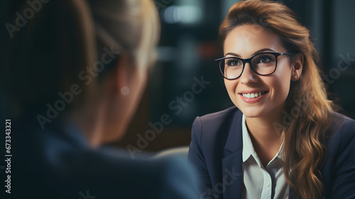 female manager in office interviewing smiling applicant