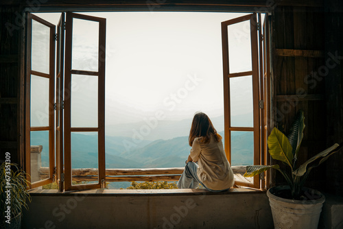 Travel woman on wooden window looking at amazing mountains view, wanderlust travel concept.