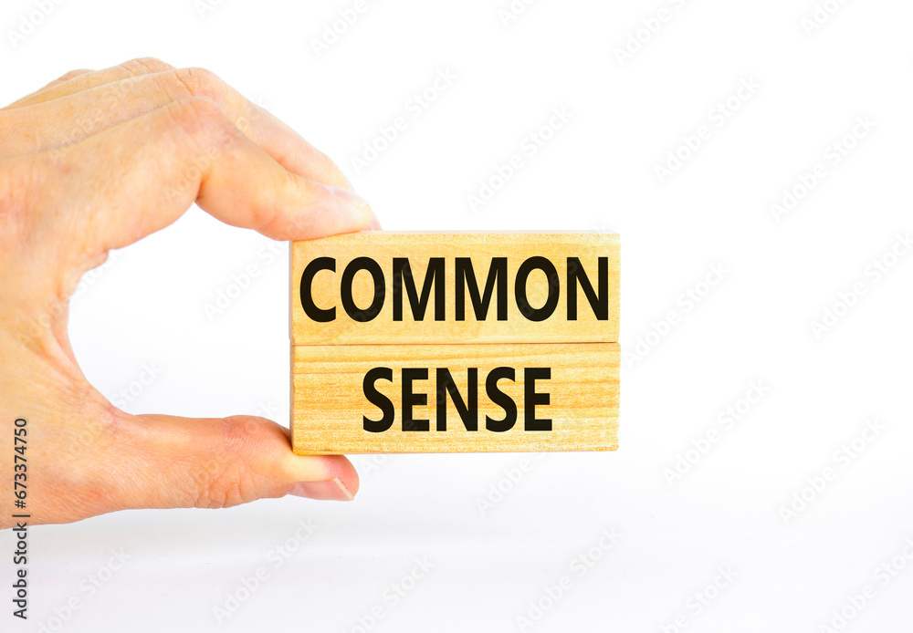 Common sense symbol. Concept words Common sense on beautiful wooden block. Beautiful white table white background. Businessman hand. Business, motivational common sense concept. Copy space. Common sense symbol. Concept words Common sense on beautiful wooden block. Beautiful white table white background. Businessman hand. Business, motivational common sense concept. Copy space.