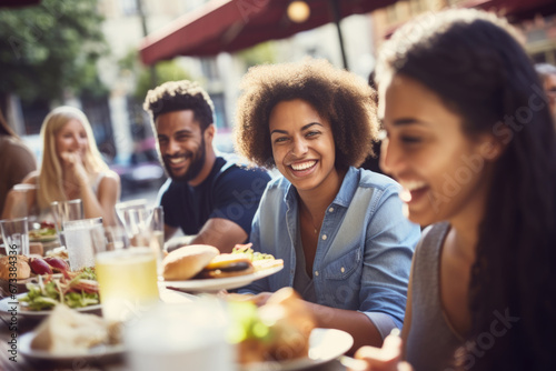 Group of happy young mix race people having lunch outdoors in Amsterdam street restaurant. Life style concept with friends having fun together on summer holiday photo